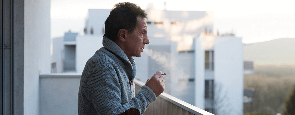 Man Smoking Cigarette on Balcony