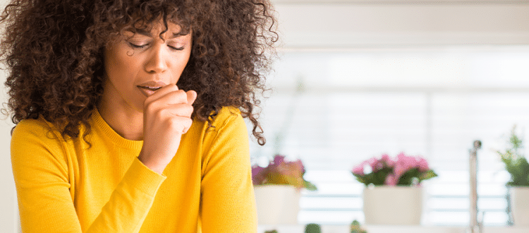 Woman covering her mouth while she coughs