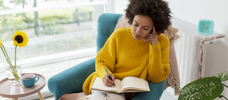 Woman contemplating a journal entry in her living room