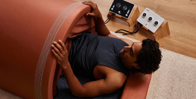 Man lying on his back inside a Curve infrared sauna dome