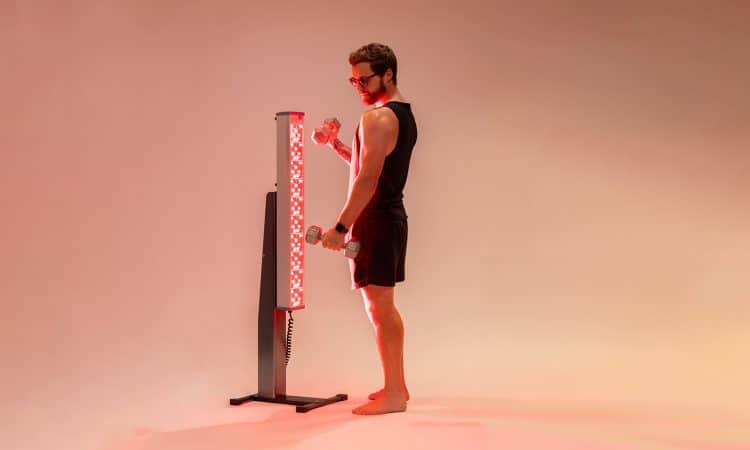 Man Lifting Weights Next to Red Light Tower